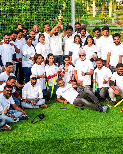 A group of players posing for a photo in their box cricket team uniforms at Go Ranch Resort.